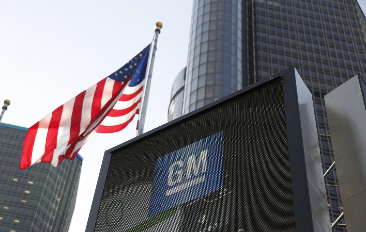 American flag billows next to a GM sign