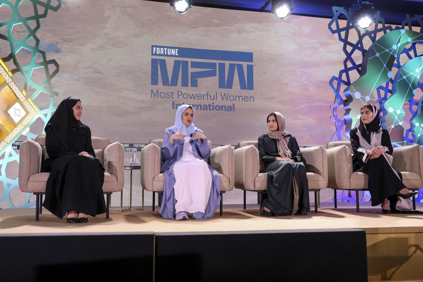 women speaking in panel on stage at a conference