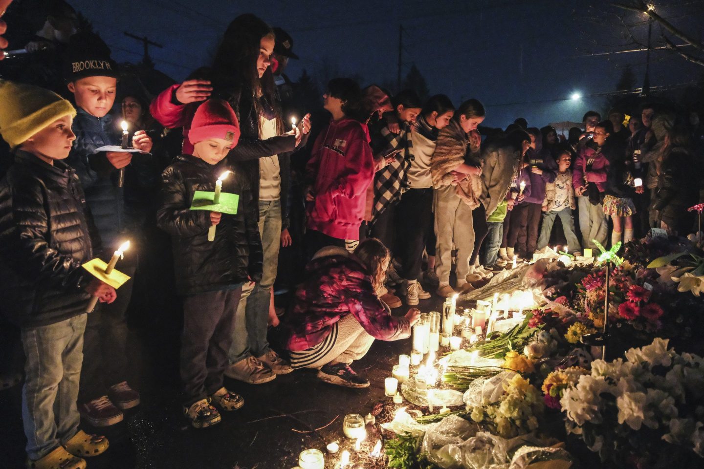 People gather at a vigil, March 22, 2024, in Renton, Wash., for four people who were killed in a car crash. 