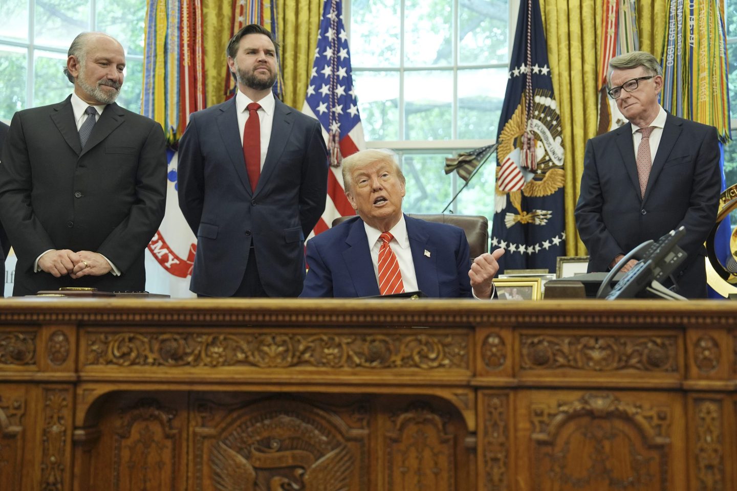 President Donald Trump, center, with from l-r., Commerce Secretary Howard Lutnick, Vice President JD Vance, and Britian's ambassador to the United States Peter Mandelson, making remarks on a trade deal between U.S. and U.K. in the Oval Office of the White House, on May 8, 2025, in Washington.