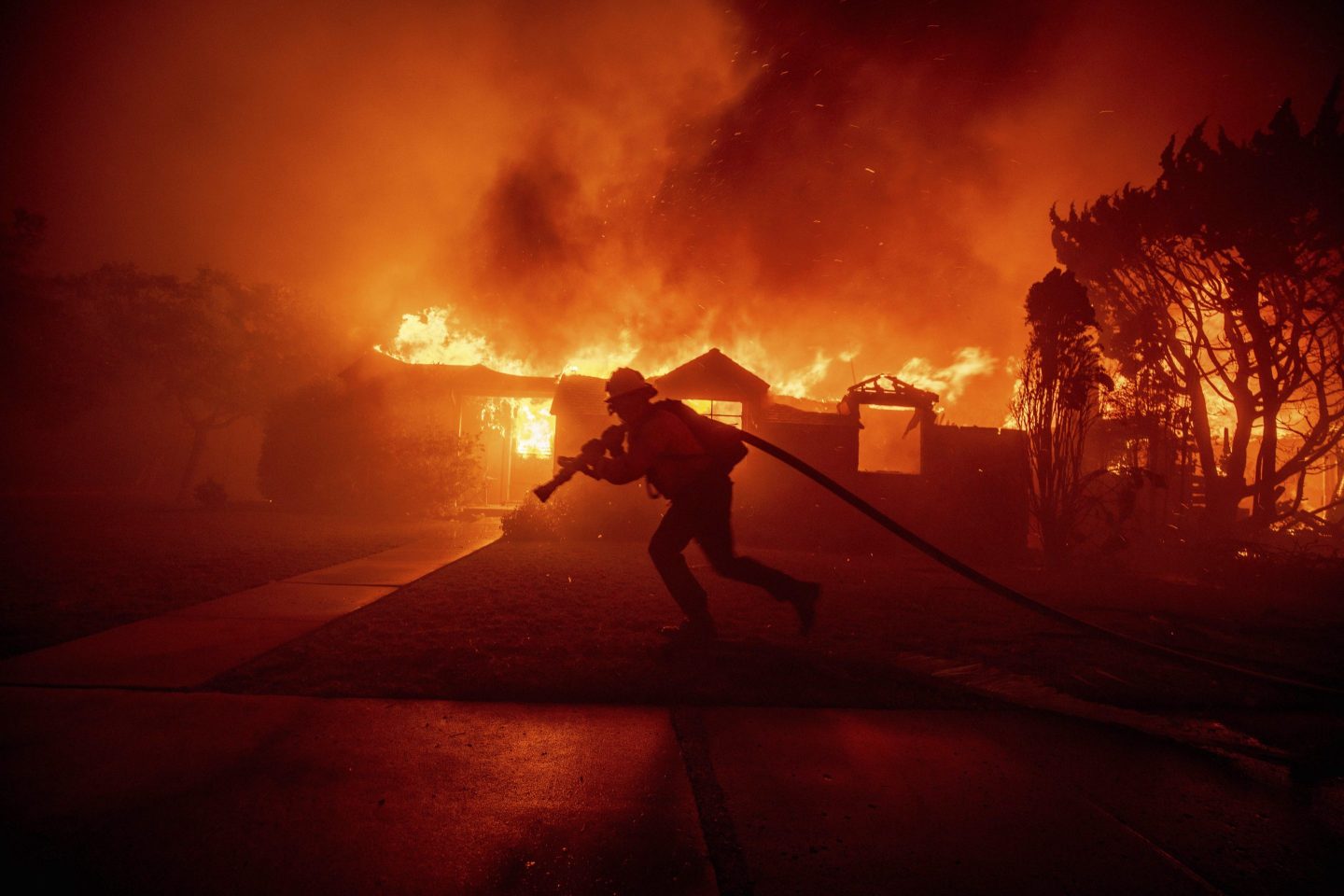 A firefighter battles the Palisades Fire as it burns a structure in the Pacific Palisades neighborhood of Los Angeles, Jan. 7, 2025.