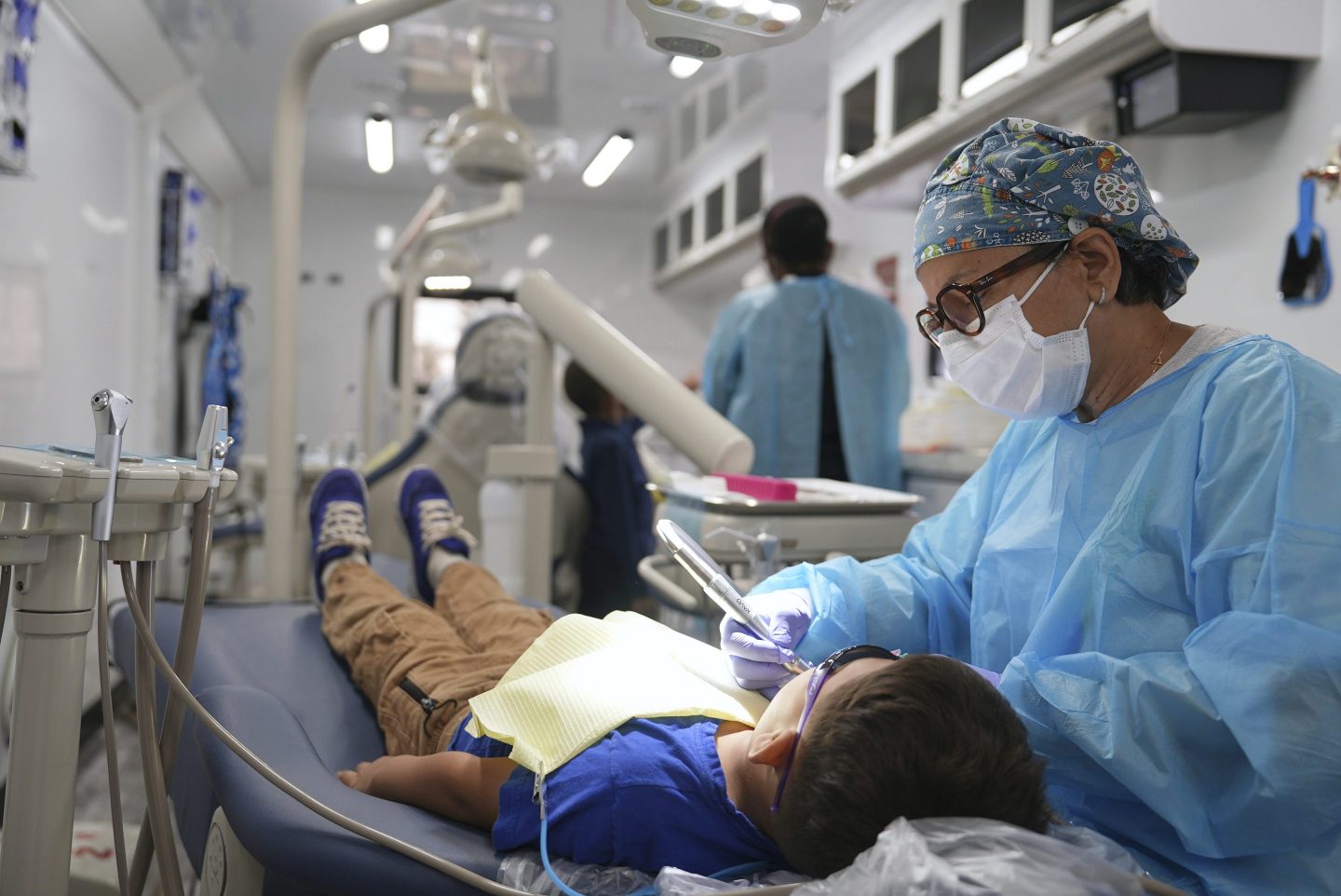 A dentist cleans the teeth of a child in the public health department’s mobile dental clinic visiting Starmount Elementary school in Charlotte, N.C., on March 20.