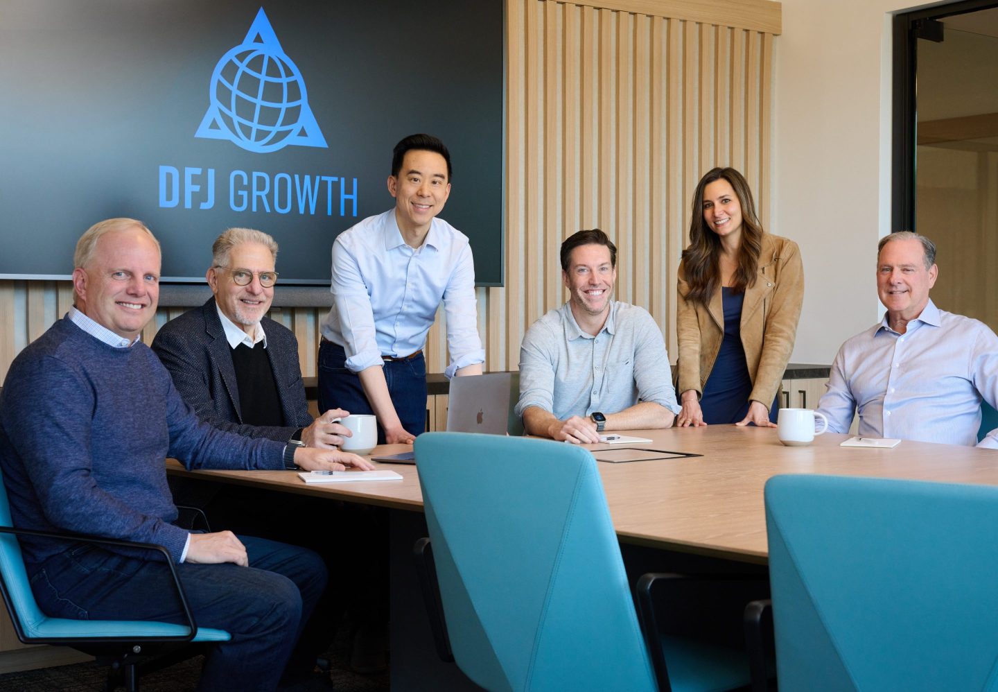 The DFJ Growth team gathered around a conference table