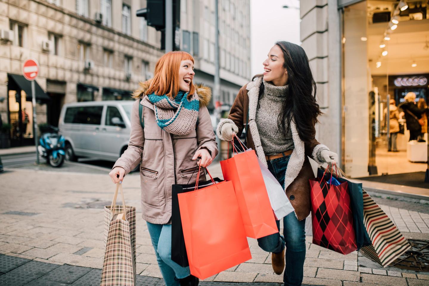 Gen Zers walking together holding many shopping bags