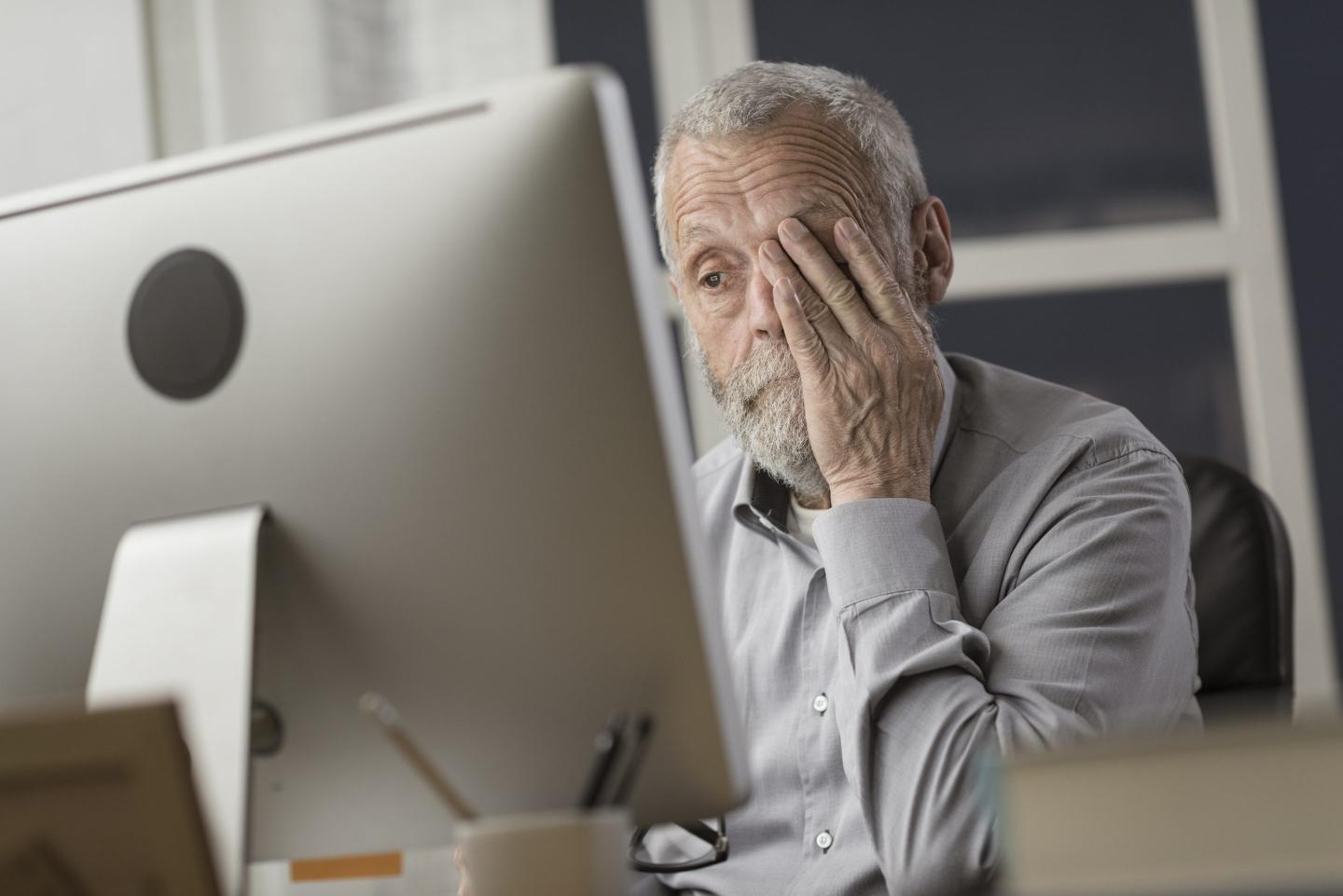 An older person looking at a computer screen