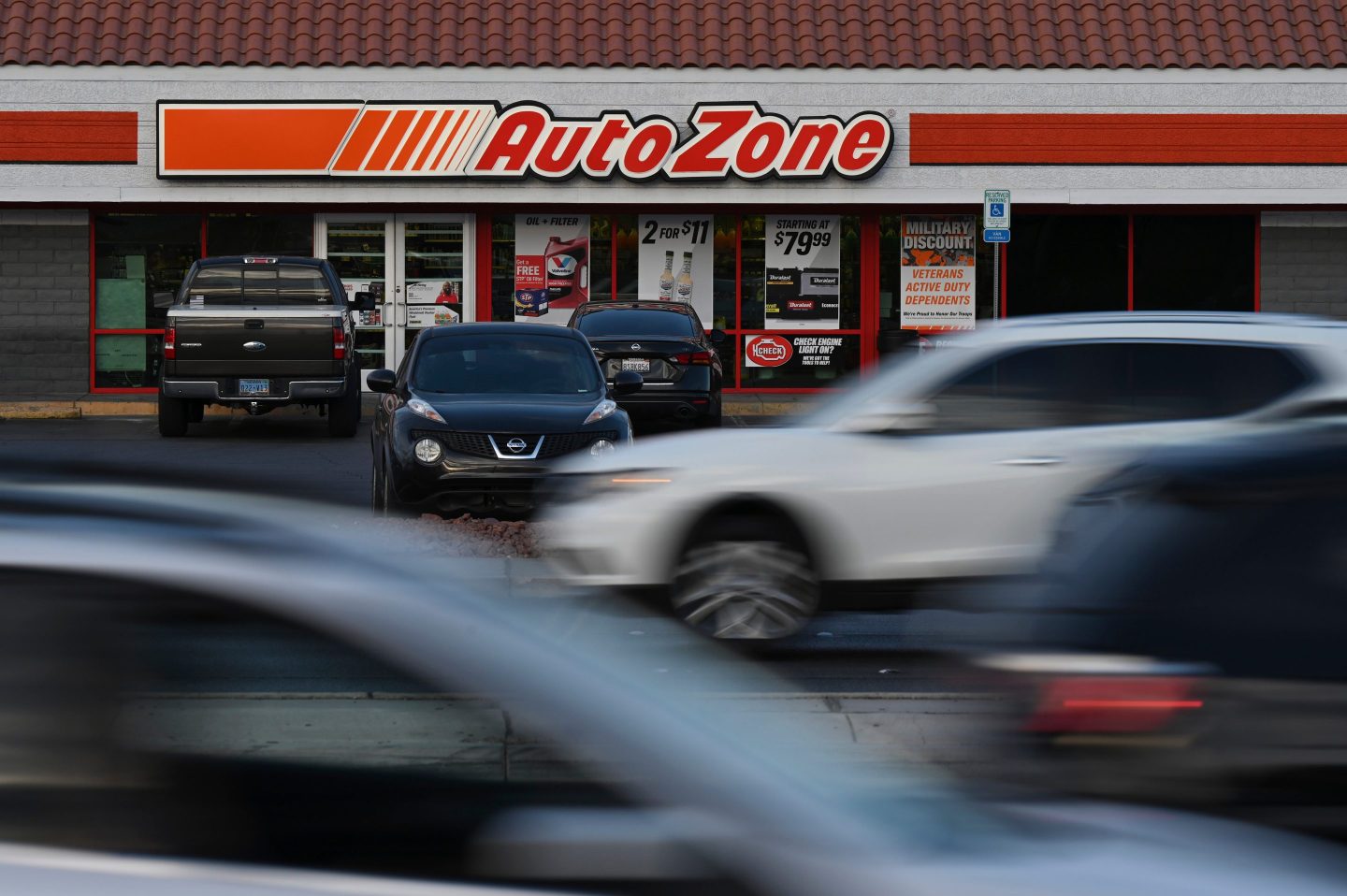 Vehicles drive by an AutoZone storefront