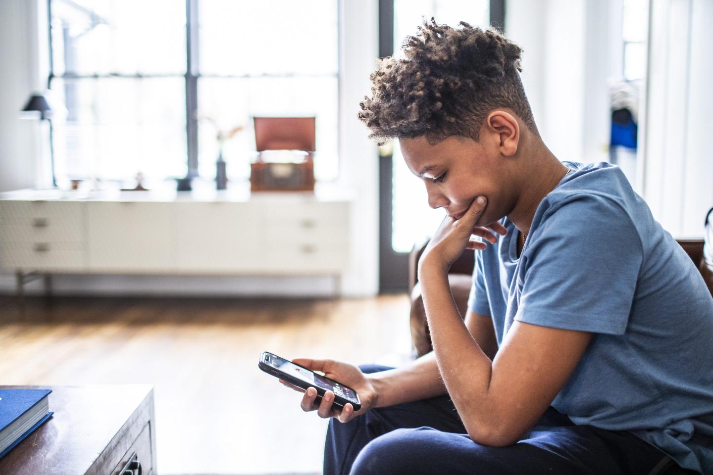 An adolescent boy on a smartphone