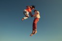Photo shows two people jumping for joy.