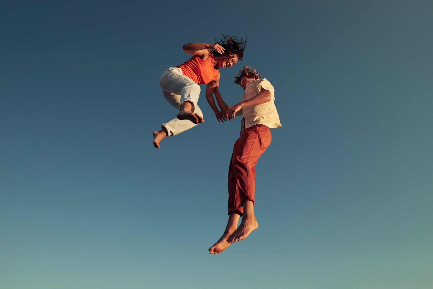 Photo shows two people jumping for joy.