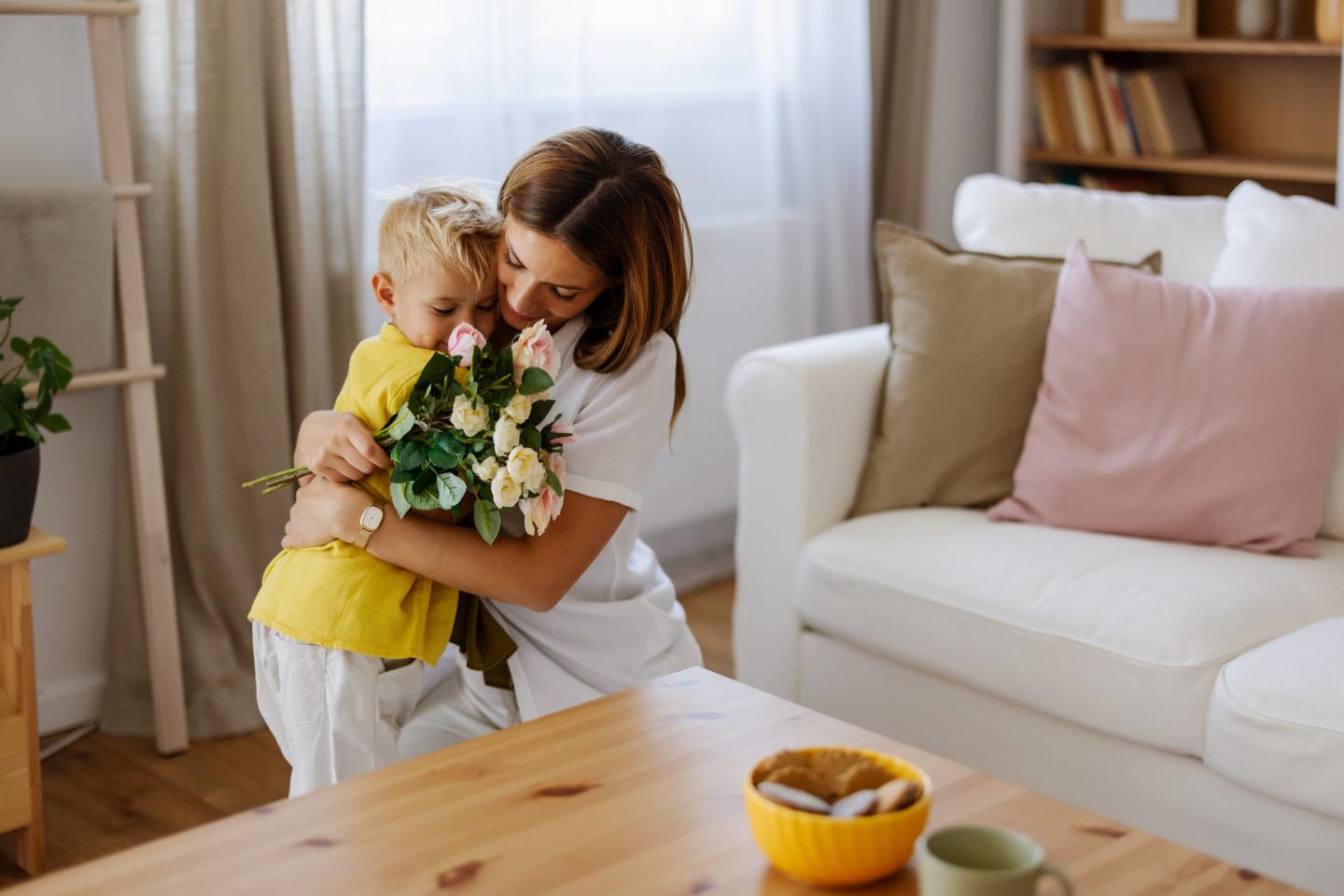 mom giving boy hug after getting flowers from him