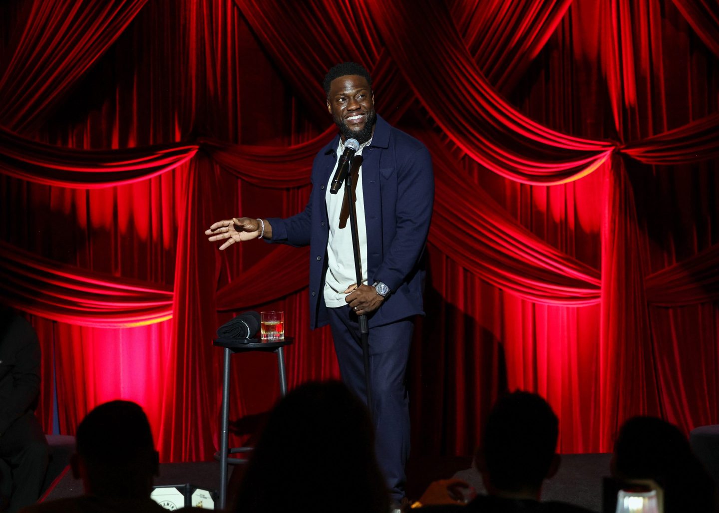 Kevin Hart holds a microphone while performing stand-up comedy