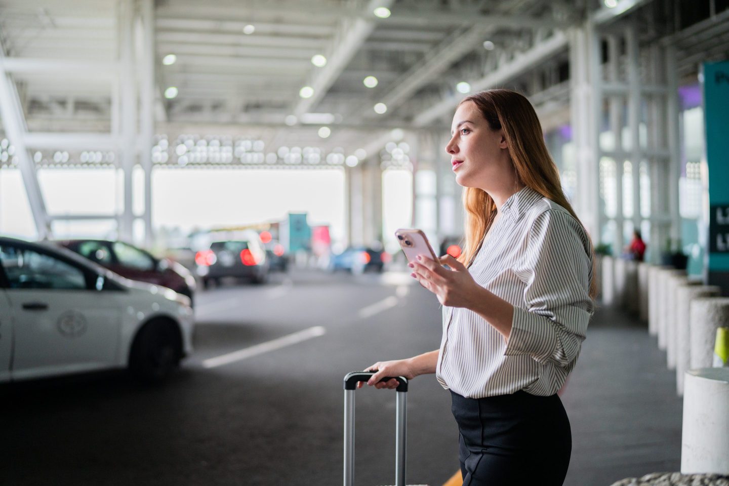 woman waiting for lyft ride at airport