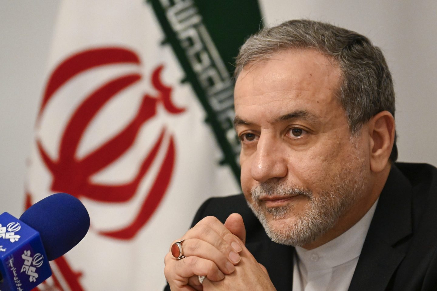 Iran's foreign minister Abbas Araghchi clasps his hands together