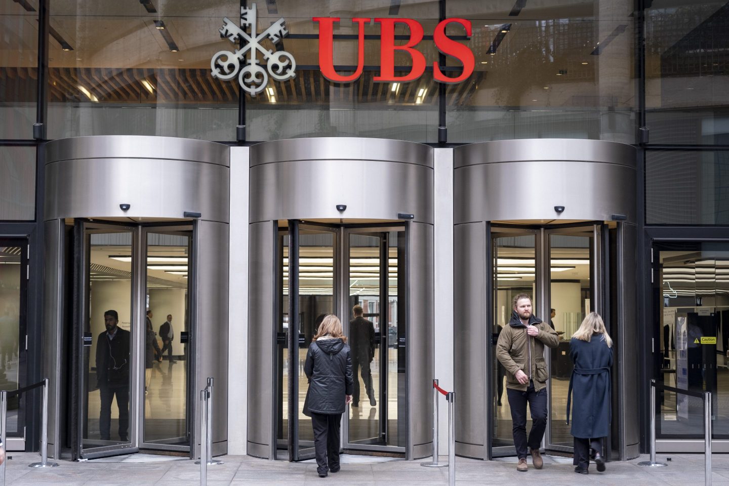 people walking in and out of UBS Bank headquarters in London