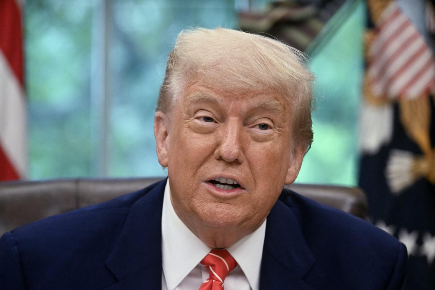 Donald Trump sits at his desk in the Oval Office.