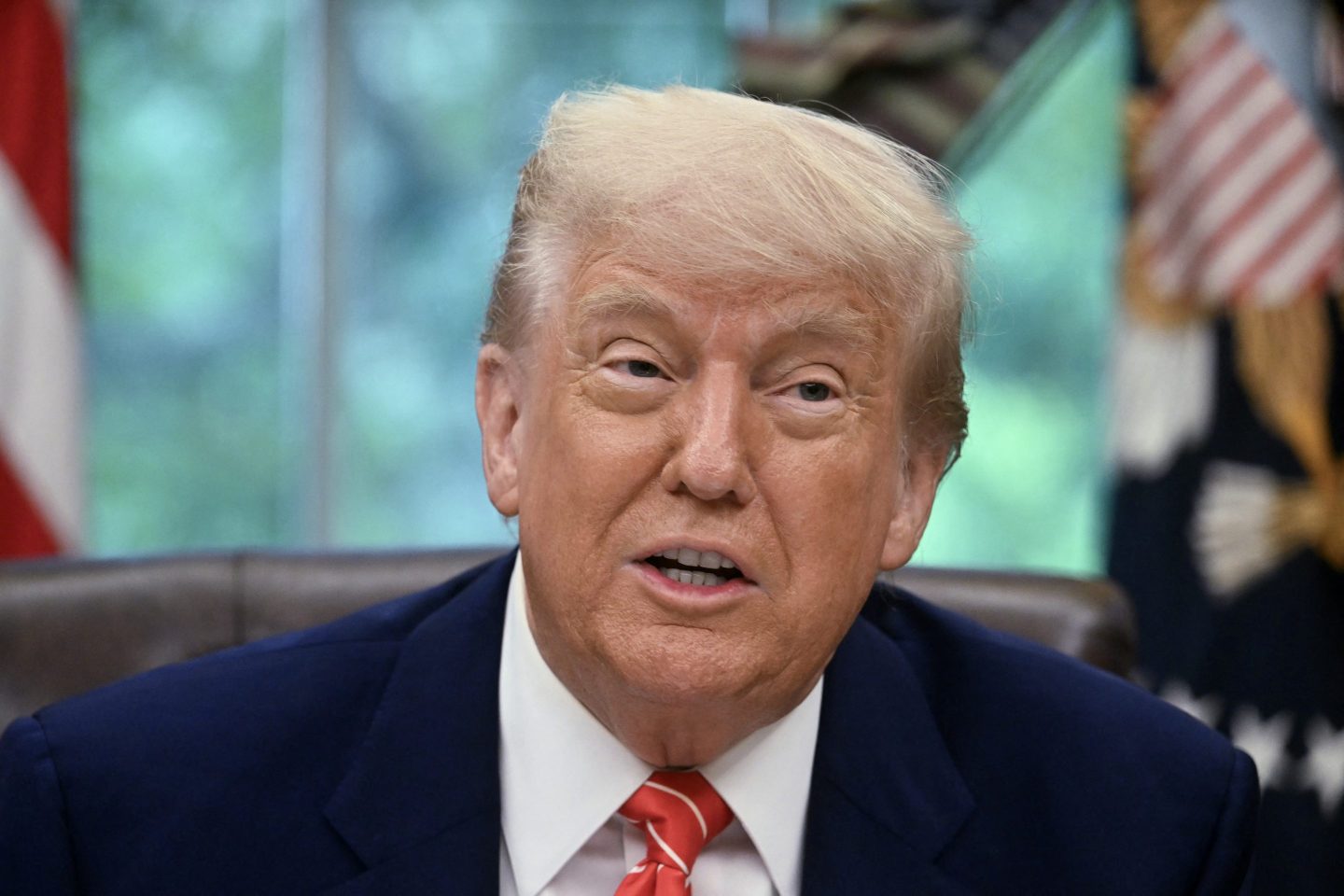 Donald Trump sits at his desk in the Oval Office.