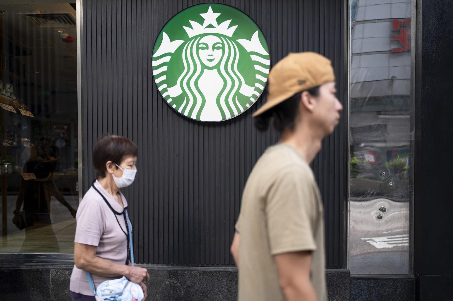 /09: Pedestrians walk past the American multinational chain Starbucks Coffee store.