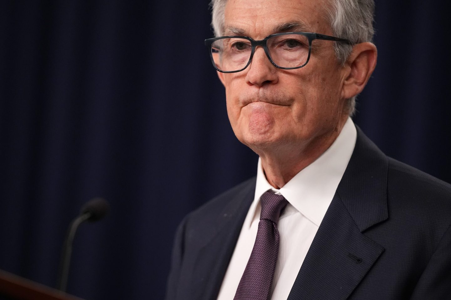 A close-up shot of Fed Chair Jerome Powell at the podium pursing his lips.
