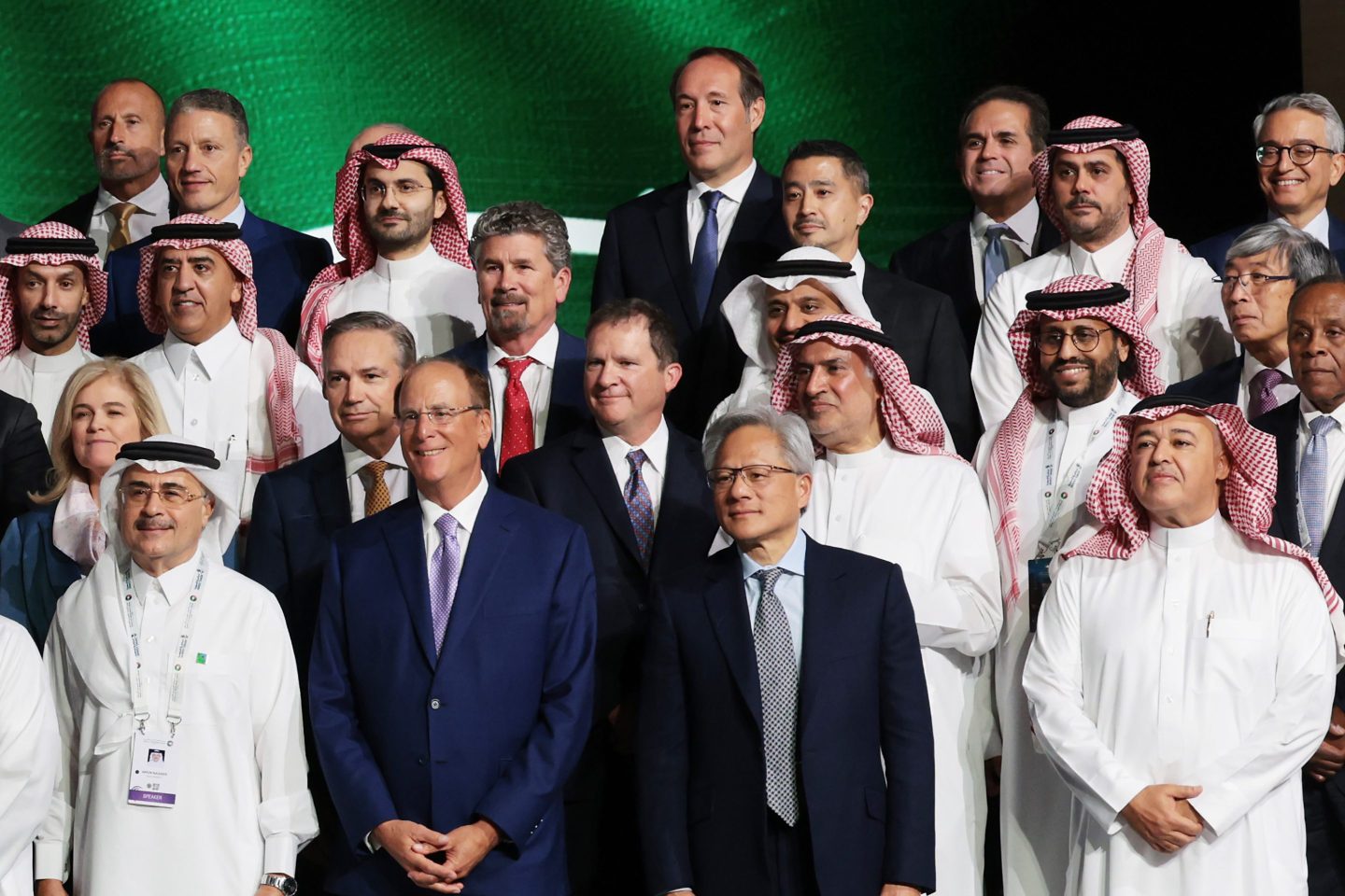 A group of several dozen businessmen stand together for a picture.