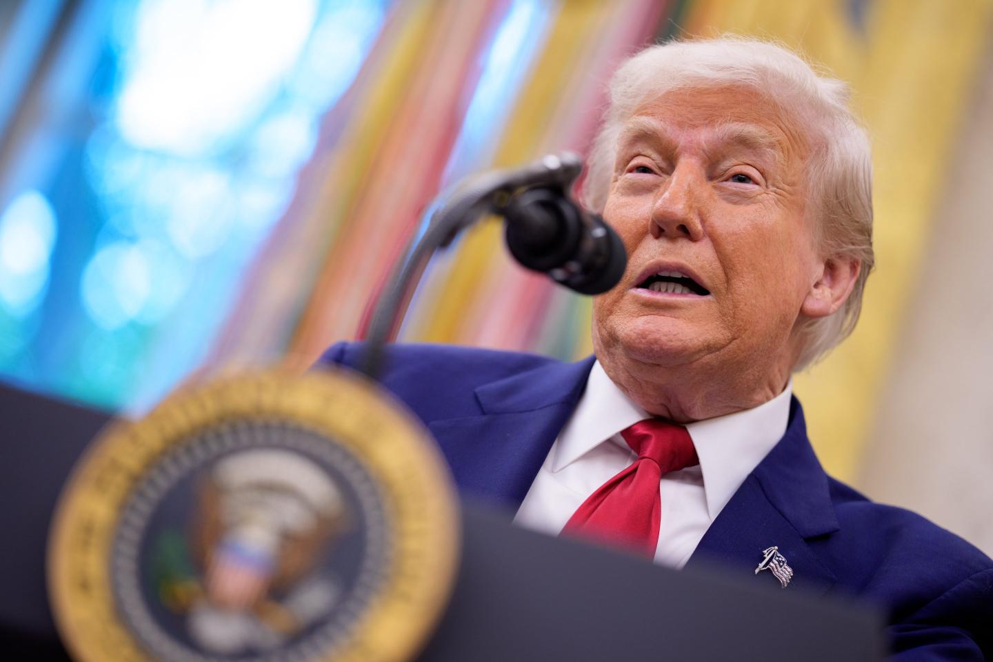 Trump speaks at a presidential podium in the Oval Office