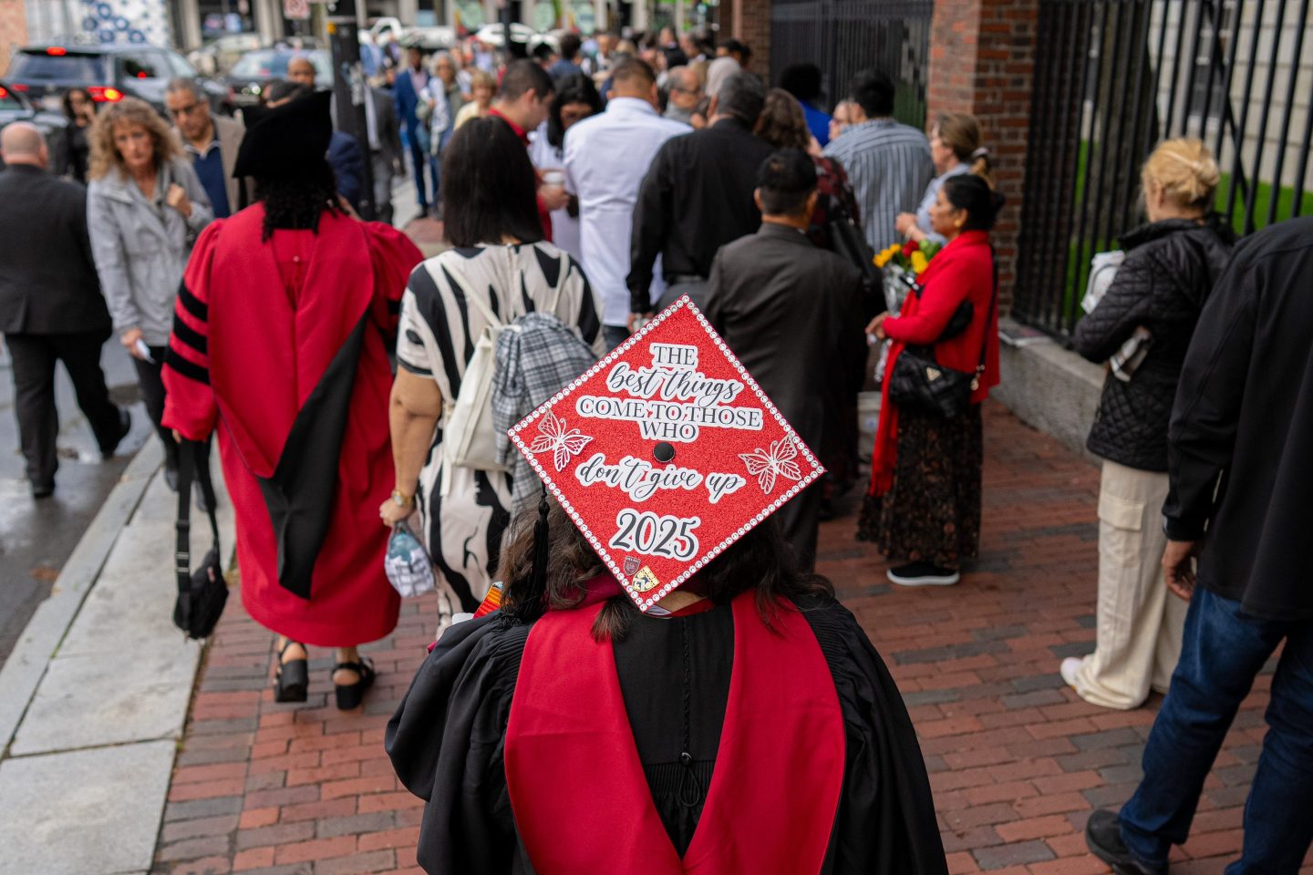 A Harvard University student wears a cap that says "The best things in life come to those who don't give up"