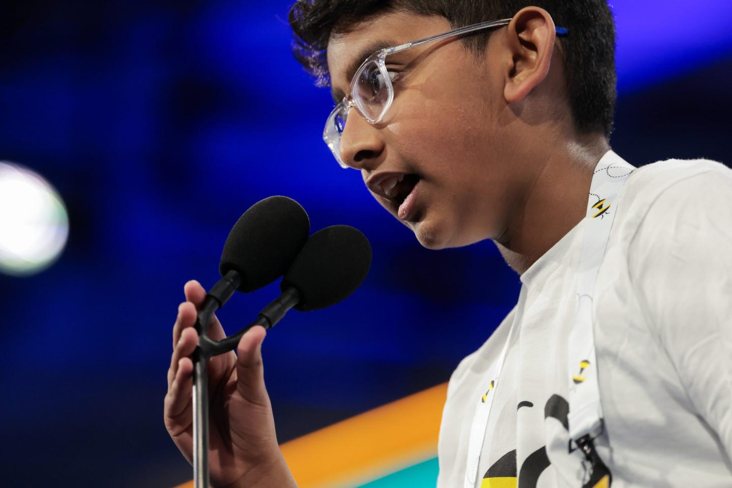 A child in front of a microphone at the Scripps National Spelling Bee