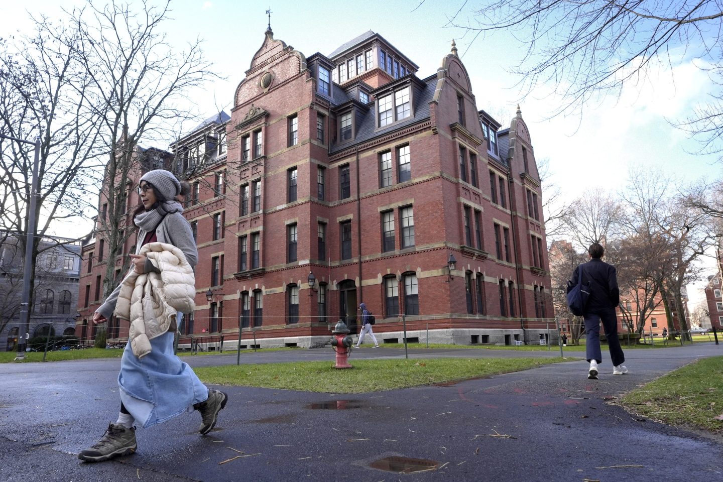 People walk between buildings, Dec. 17, 2024, on the campus of Harvard University in Cambridge, Mass.