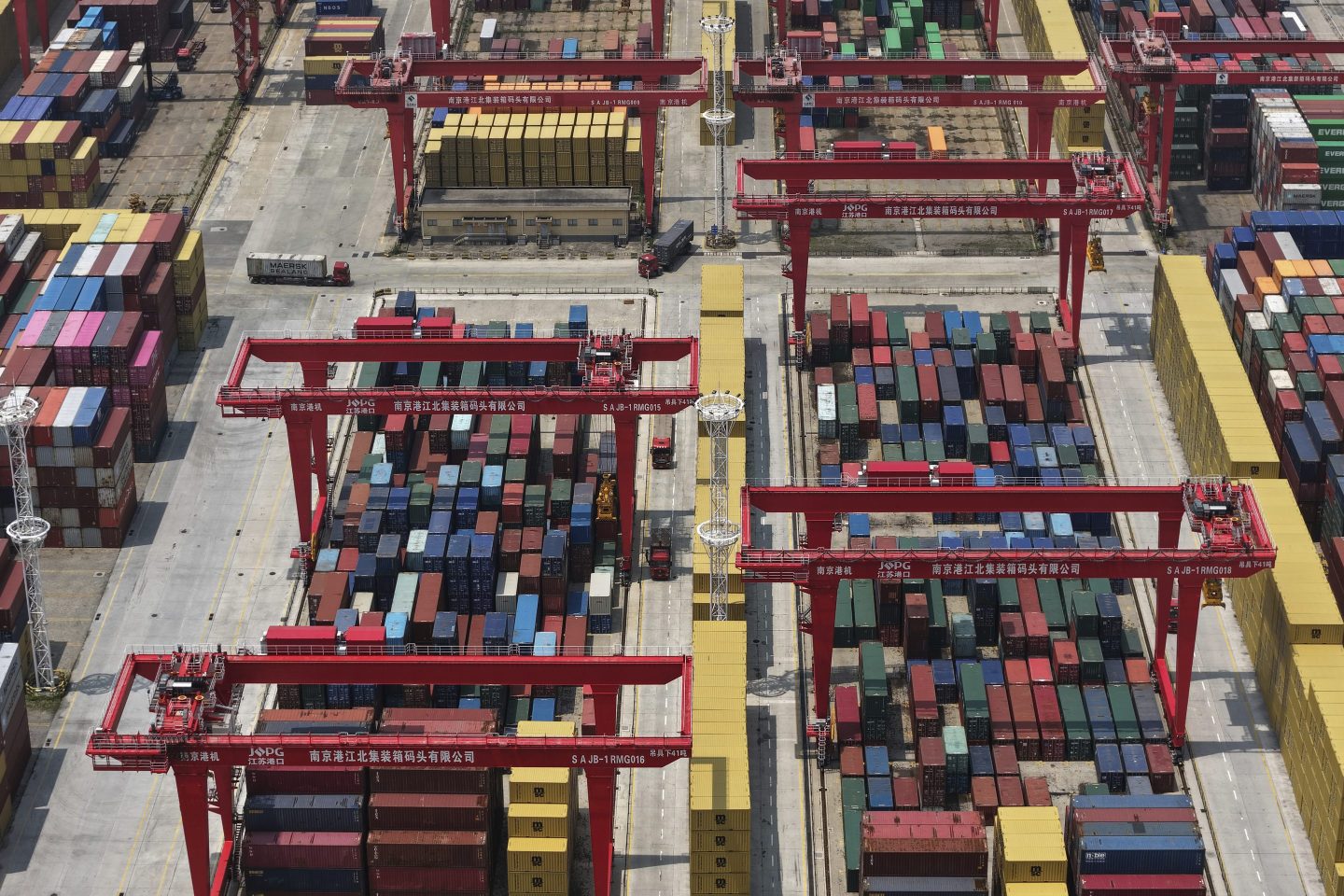 Trucks move through containers piled up at a container terminal in Nanjing in east China's Jiangsu province on June 3.