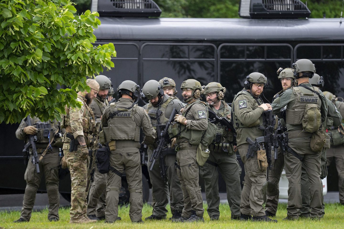 Law enforcement officers including local police, sheriffs and the FBI, stage less than a mile from a shooting in Brooklyn Park, Minn. on Saturday.