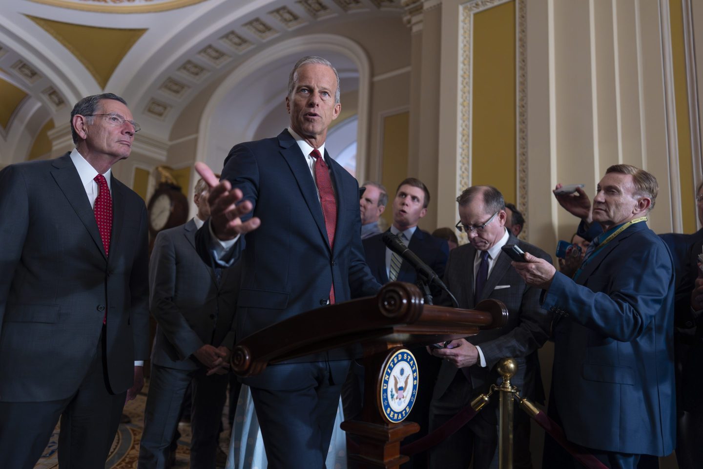 Senate Majority Leader John Thune, R-S.D., center, joined at left by Sen. John Barrasso, R-Wyo., the GOP whip, speaks to reporters after Republican senators met with Treasury Secretary Scott Bessent and worked on President Donald Trump's tax and immigration megabill so they can have on his desk by July 4, at the Capitol in Washington, on June 24, 2025.