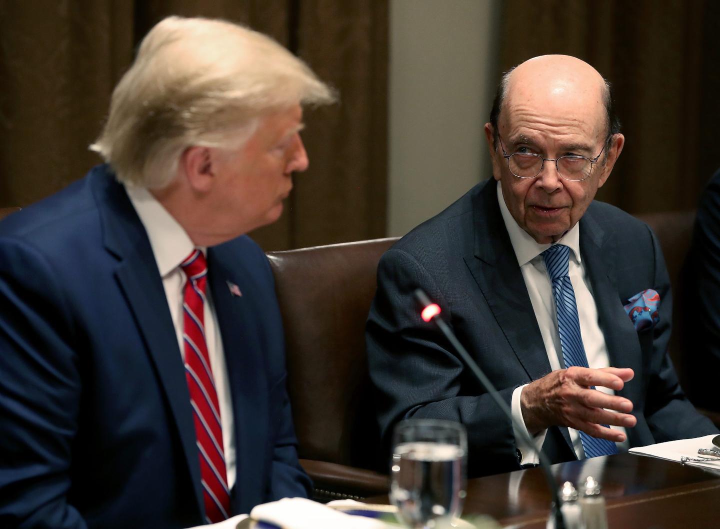 U.S. President Donald Trump listens to former Commerce Secretary Wilbur Ross speak