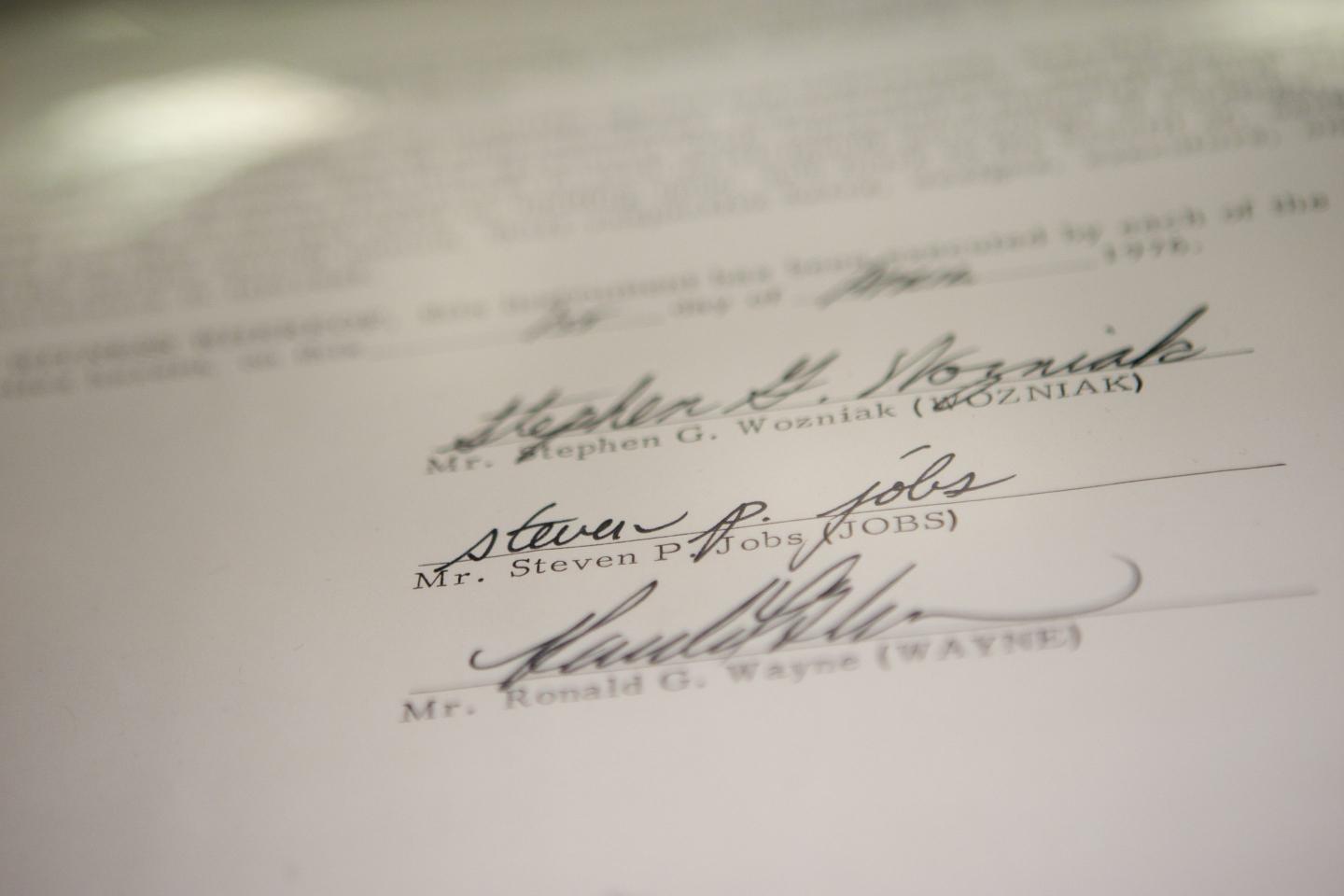 Photo of three signatures at the bottom of a contract