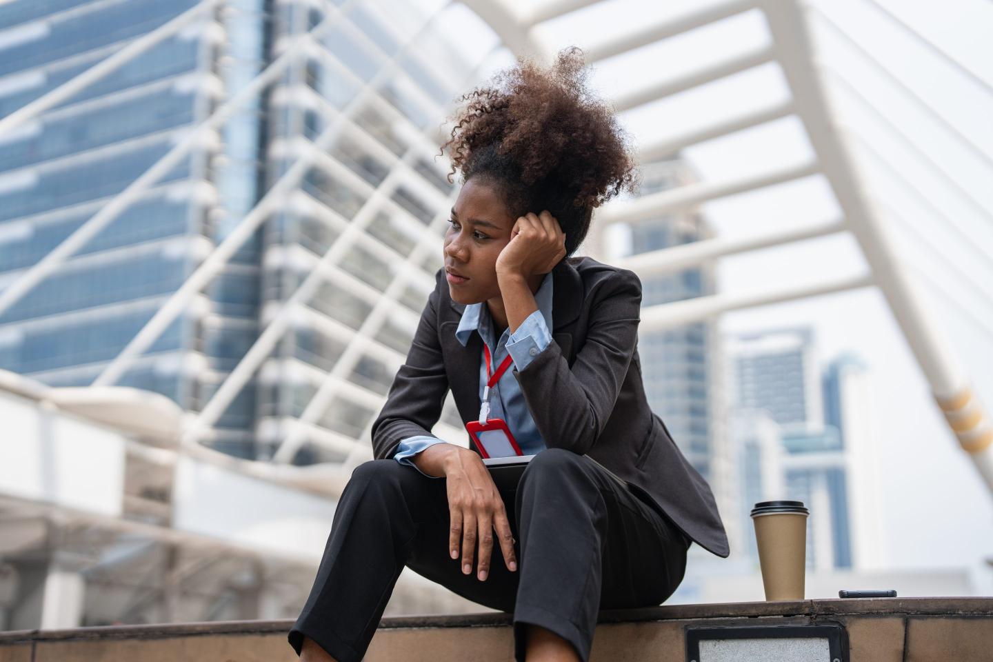 A young woman sits with her head in her hands