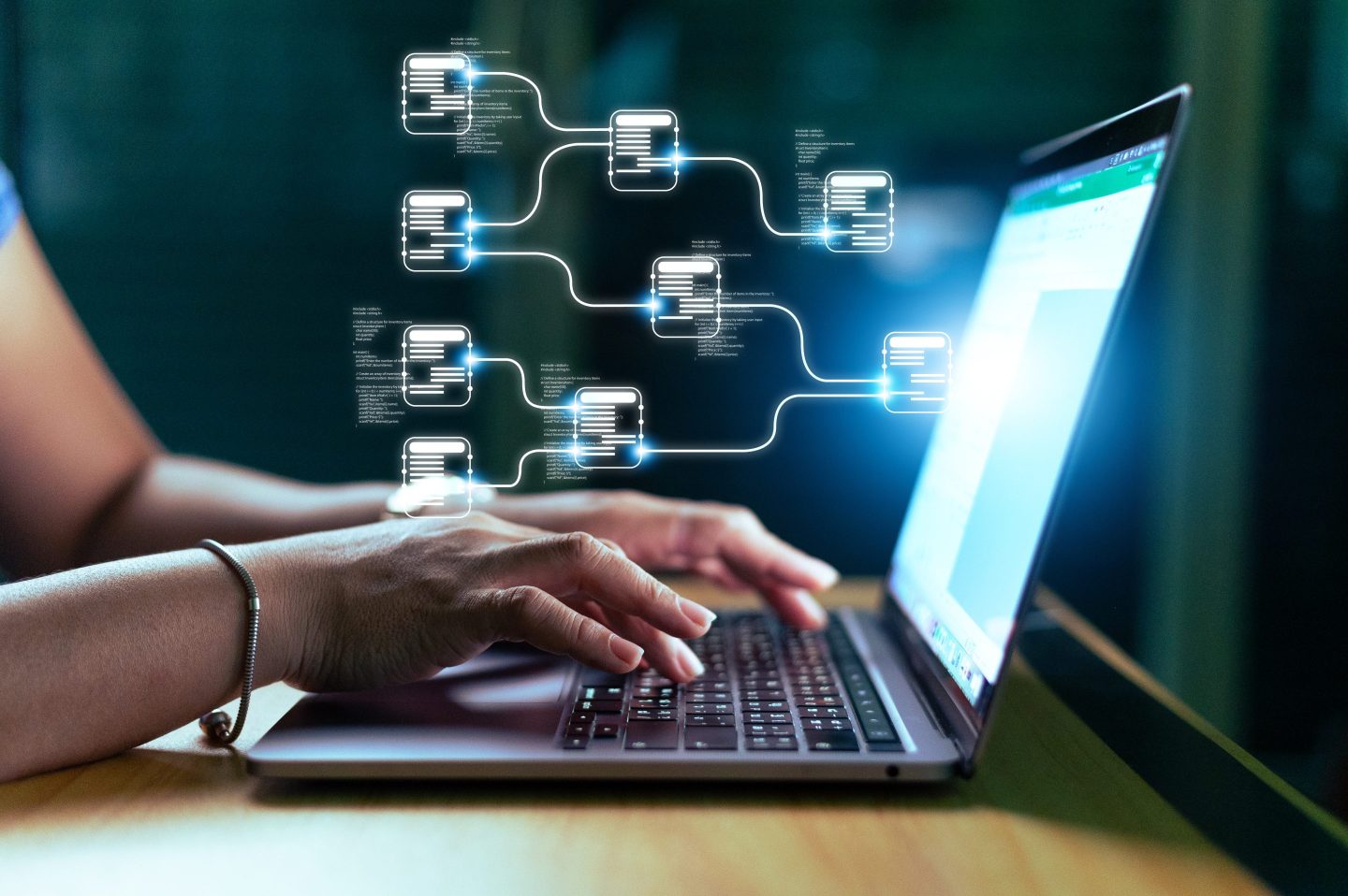 woman using laptop computer with hologram of data emitting from the screen