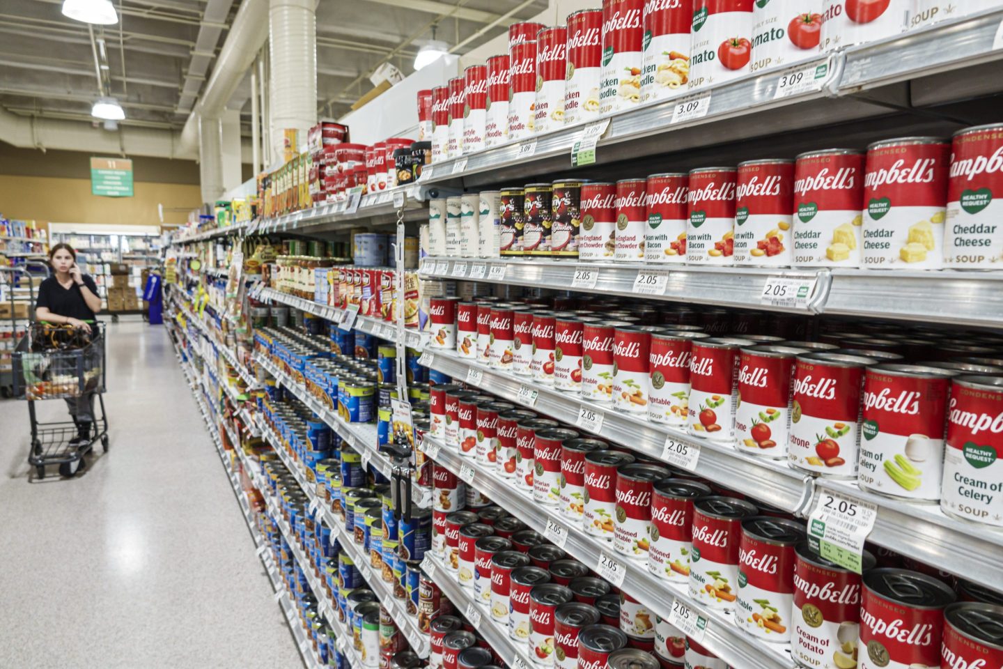 woman shopping for Campbell's soup in grocery store