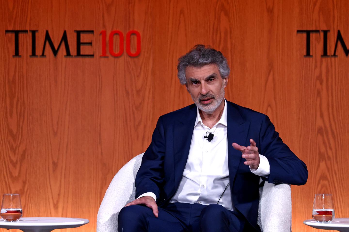 Yoshua Bengio sitting on a chair on stage at Time's Summit.