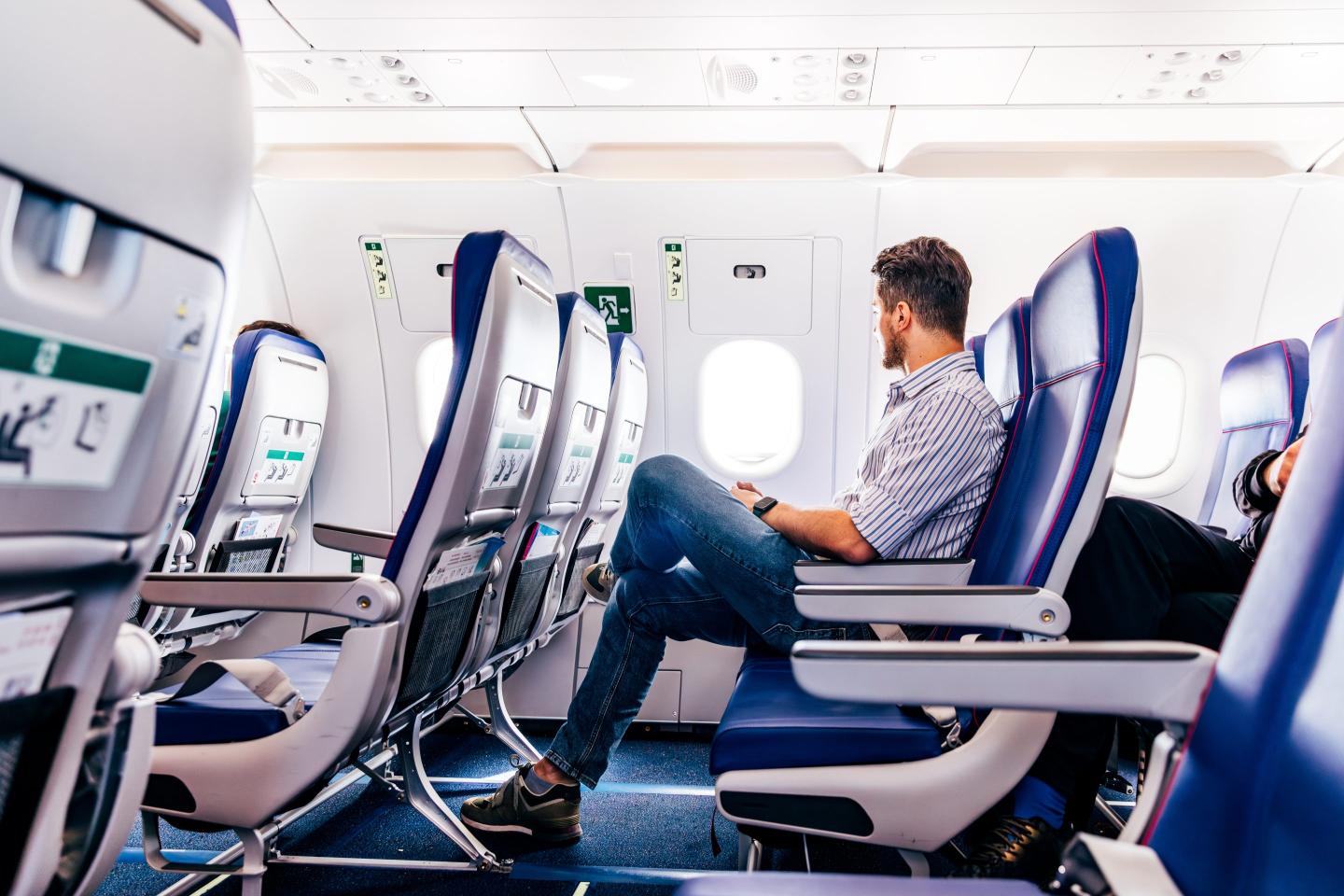 man looking out window on plane