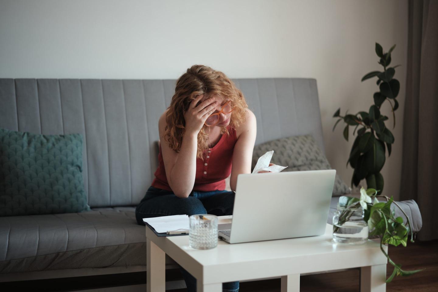 Woman looking stressed paying bills