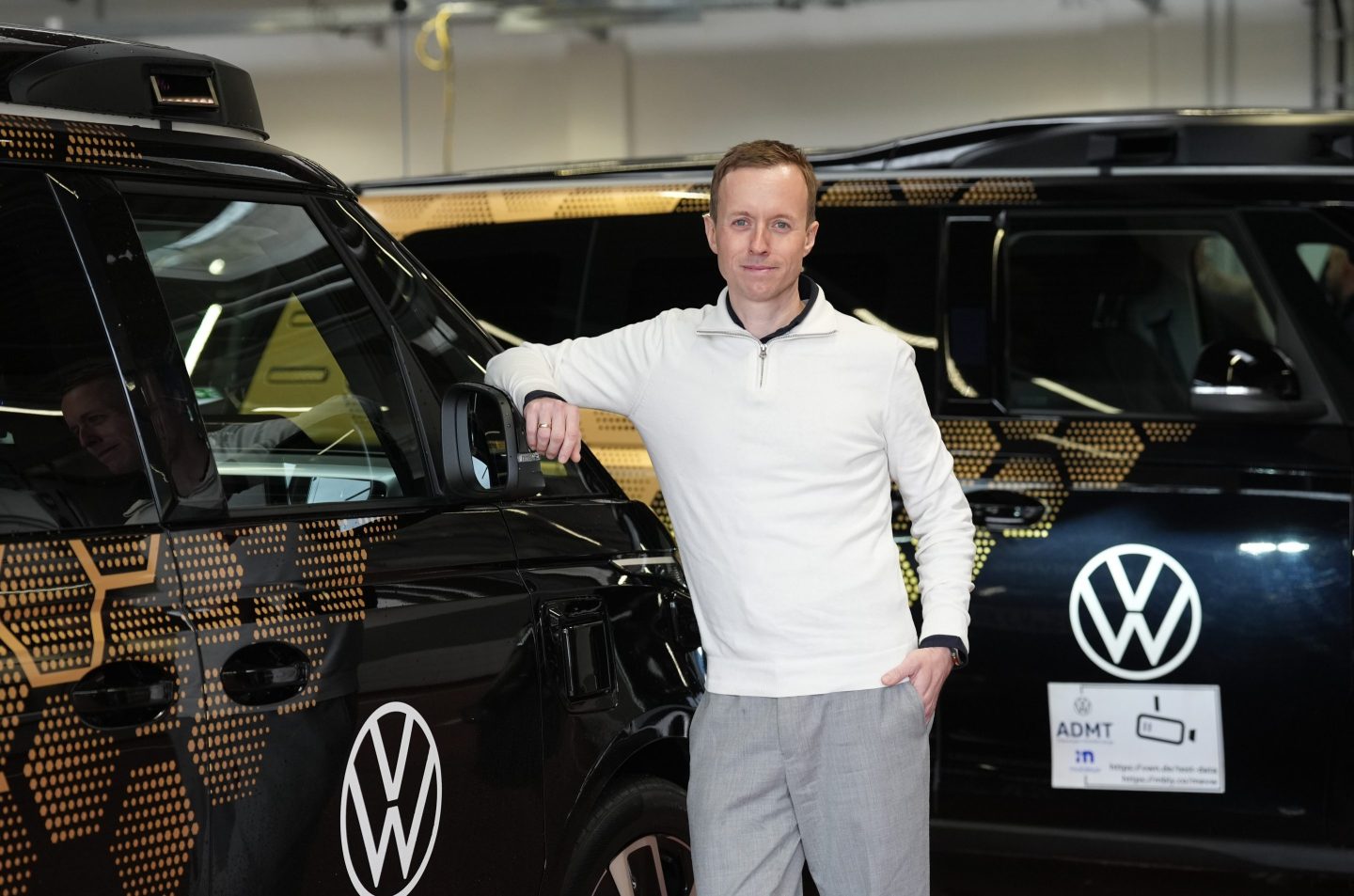 Sascha Meyer, Managing Director of Moia GmbH, stands at the Moia hub in front of several autonomously driving ID. Buzz AD from Volkswagen.