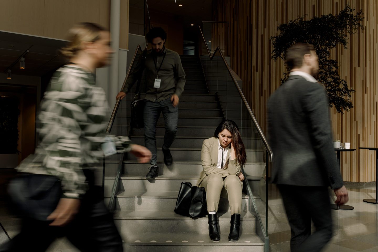 Frustrated businesswoman sitting on staircase at convention center