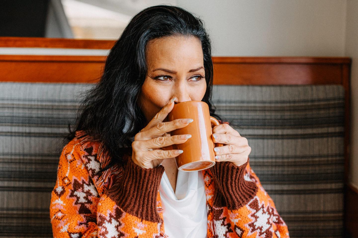 Photo of a woman sipping from a mug