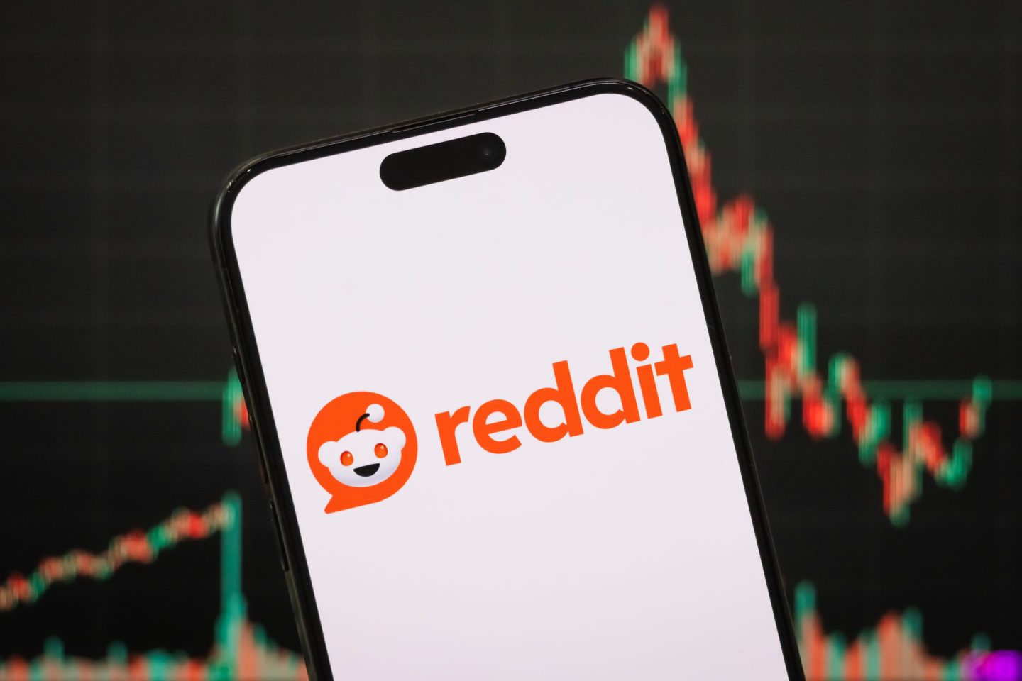 the logo of Reddit, Inc. is displayed on a smartphone screen, with the company's latest stock market performance