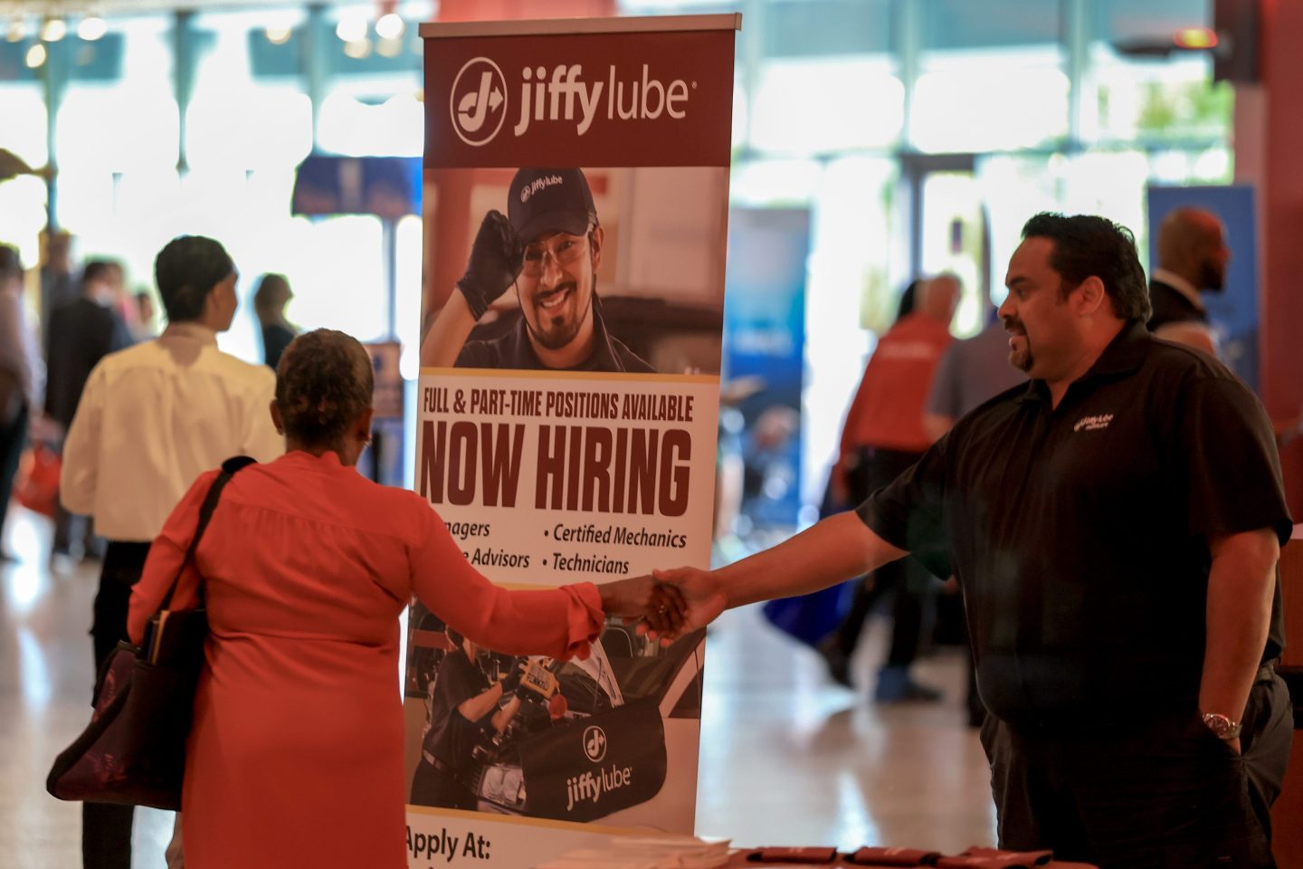 Two people shake hands at a job fair