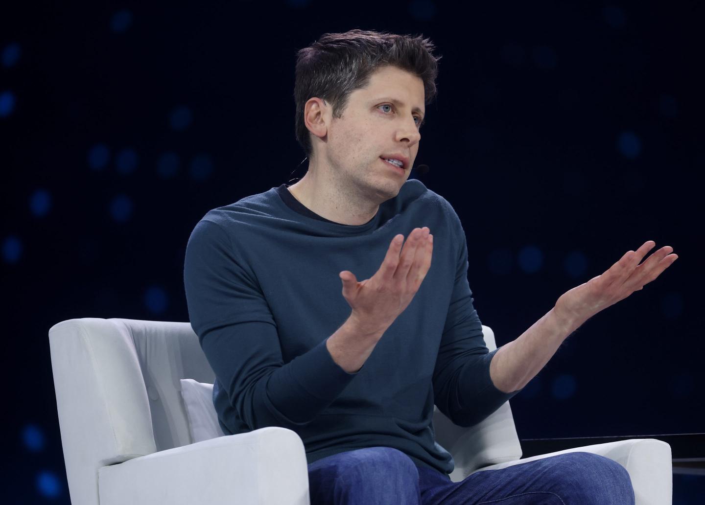 Sam Altman shrugs with both his hands up