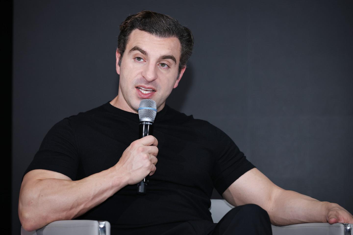 Brian Chesky speaks into a microphone