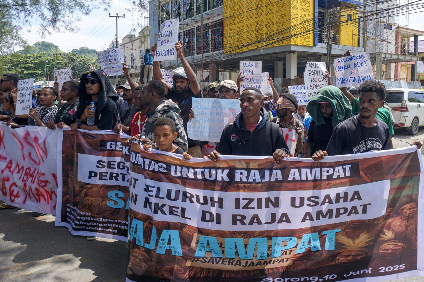 Papuans hold placards reading "revoke all nickel mining permits in Raja Ampat immediately" during a protest march to the Southwest Papua Governor's office in Sorong on June 10, 2025.
