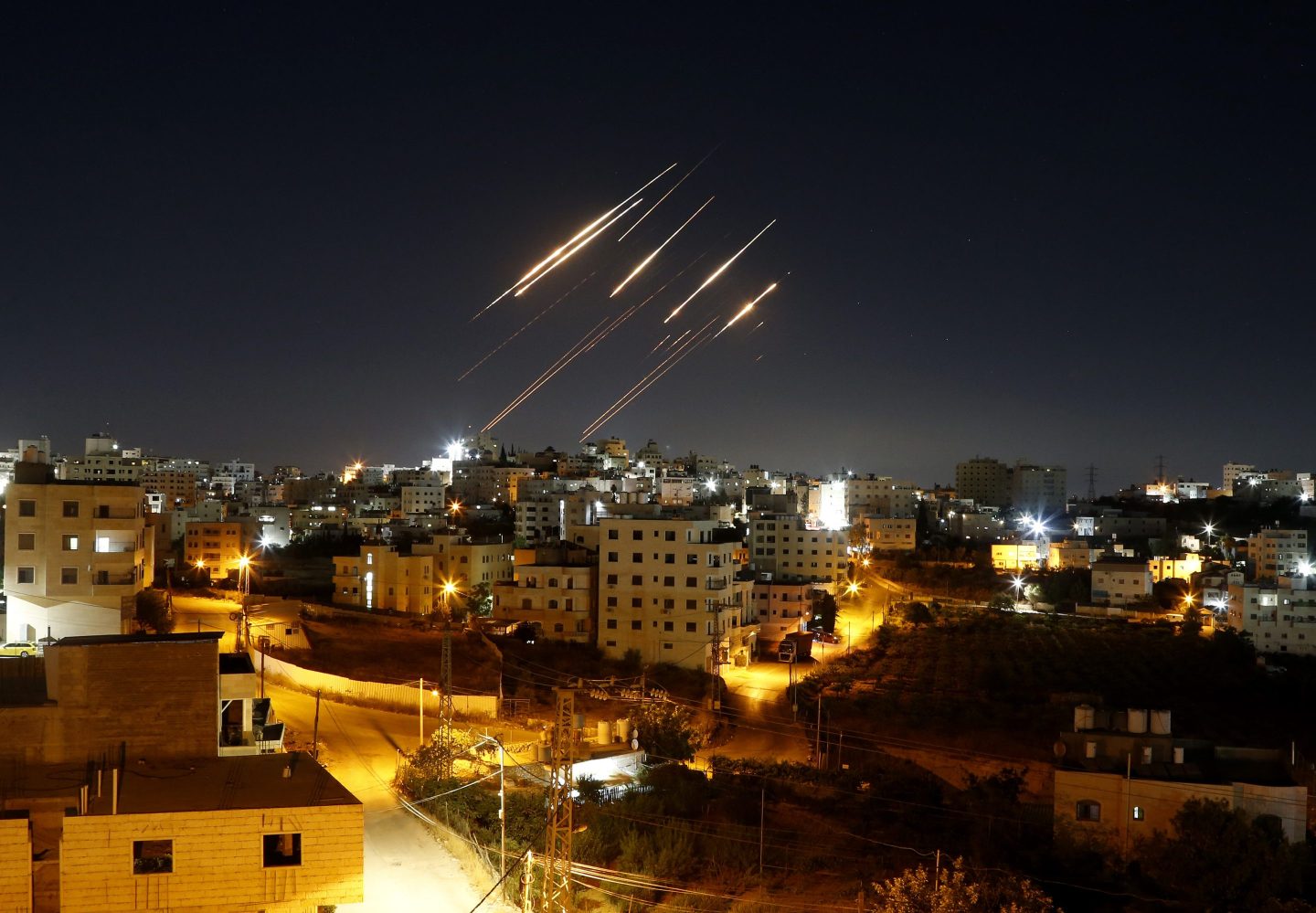 Streaks of light from Iranian ballistic missiles are seen in the night sky above Hebron, West Bank, as Iran made retaliatory strikes against Israel.