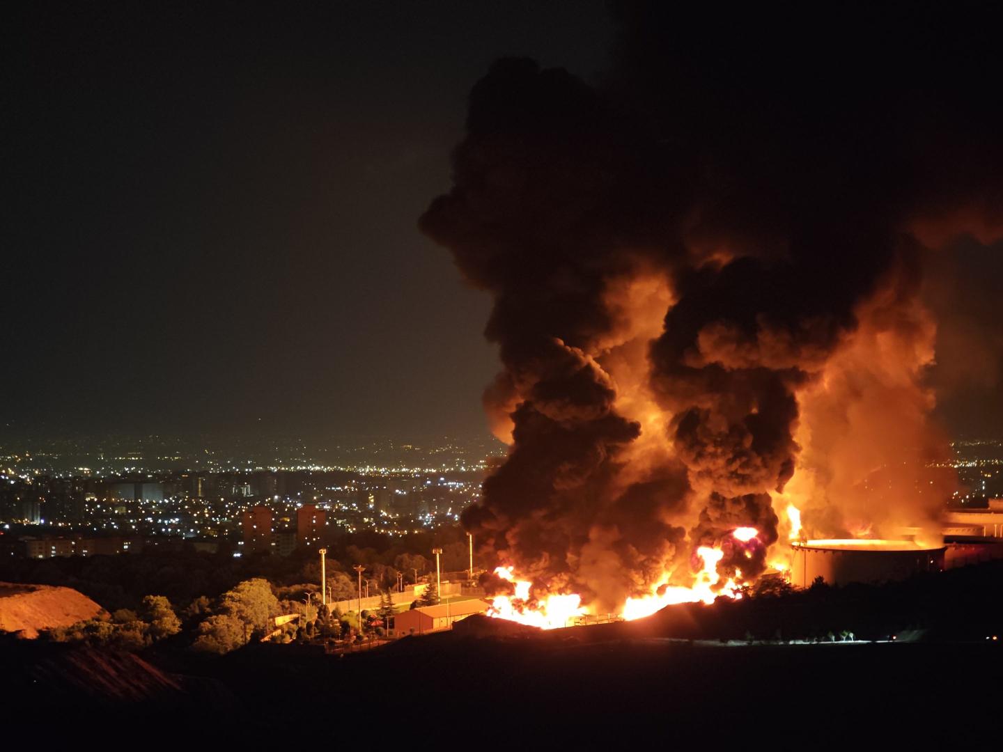 Fire and smoke rise into the night sky after an Israeli attack on the Shahran oil depot.