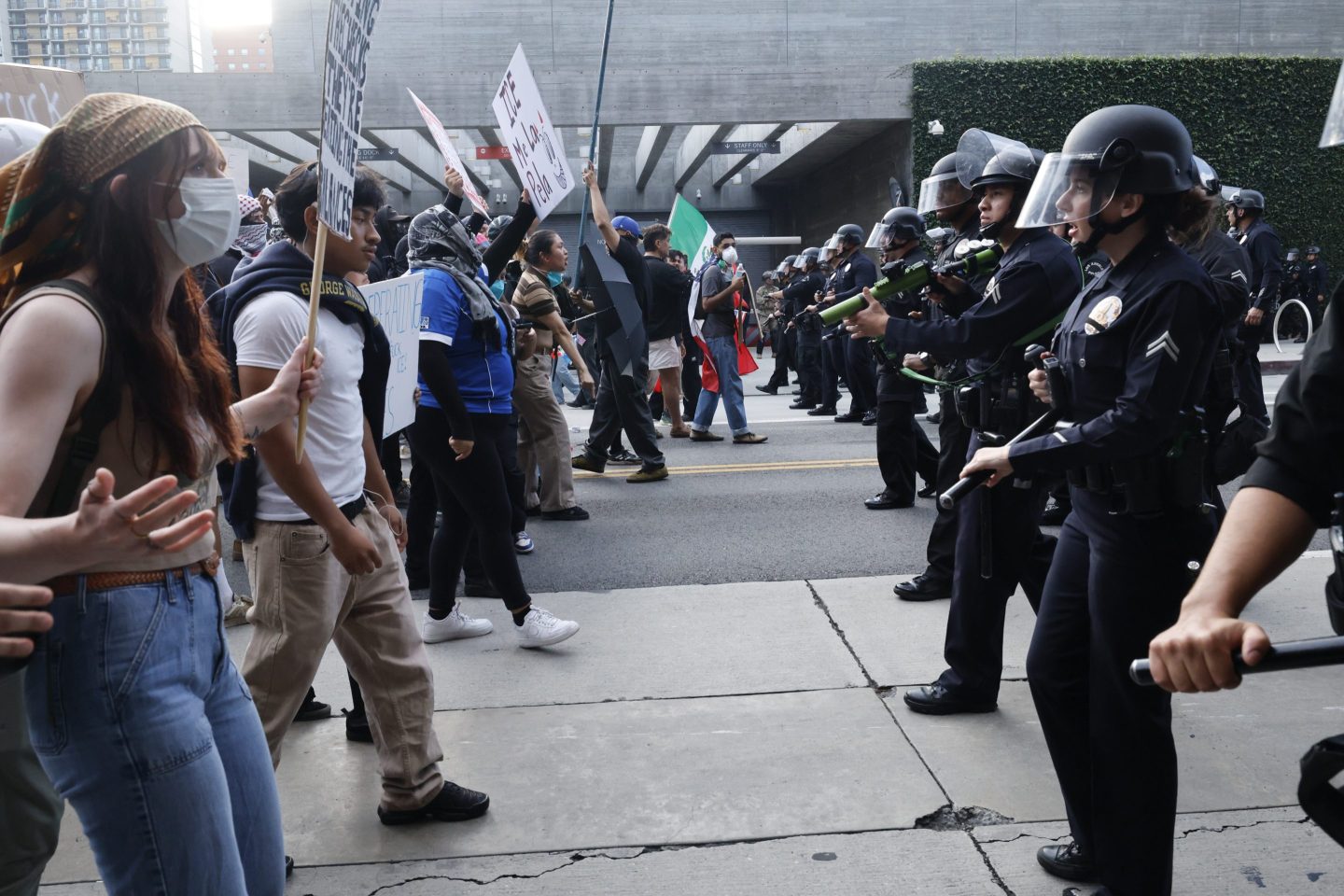 Anti-ICE protesters are pushed back by LAPD on Broadway during the "No Kings Day" protest in Downtown