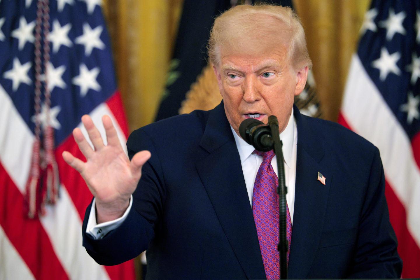 President Donald Trump holds up his hand during a press conference in June.